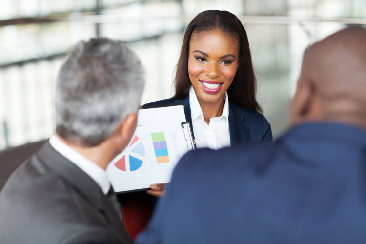 23152744 - beautiful young african businesswoman explaining graph to business team